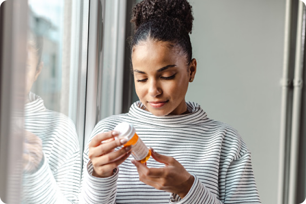 woman holding medication bottle reading label